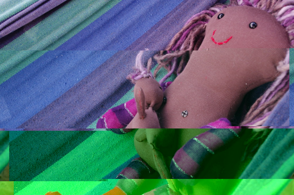 A baby resting in a hammock with supportive care